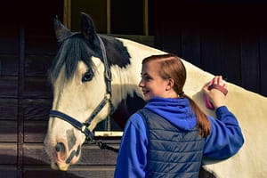 Volunteer grooming a horse