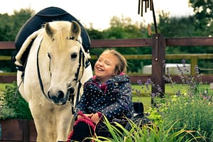 Young Girl Holds Leading Rein & Smiles at RDA Pony