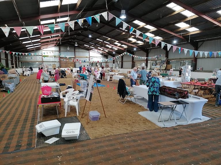 craft fair being set up inside indoor sand school, tables and bunting are in place