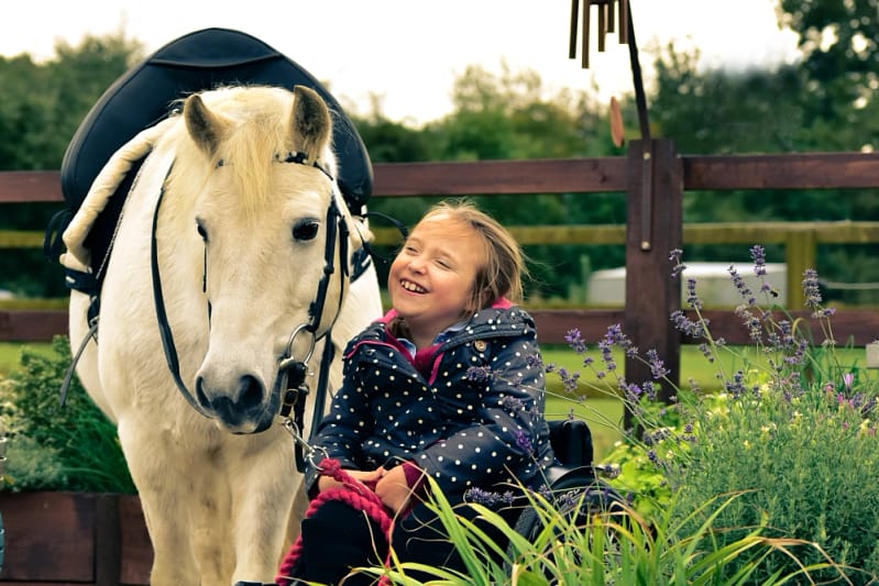 Young girl smiling at pony
